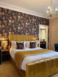 奥本Rose Villa的一间卧室配有一张带花卉壁纸的大床