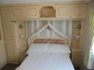 英戈尔德梅尔斯5 Berth on Coral Beach (Granada)的一间卧室配有一张带床头板和书架的床