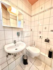 汉堡Hotel Nord的白色的浴室设有水槽和卫生间。