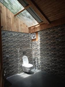 吉布LITTLE WOOD TREEHOUSE的砖墙内白色卫生间的浴室