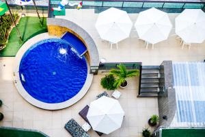 累西腓Hotel Golden Park Recife Boa Viagem的享有带遮阳伞和椅子的游泳池的顶部景致