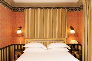 巴黎Hôtel Bourg Tibourg的一间卧室配有一张床和条纹墙