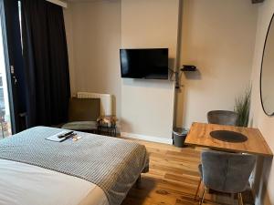 鲁汶Good night Leuven -Self check-in的一间酒店客房,配有一张床铺、一张桌子和一台电视