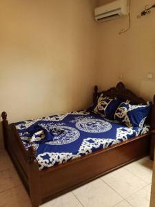 雅温得Résidence La ROSÉE的一间卧室配有一张带蓝色和白色棉被的床