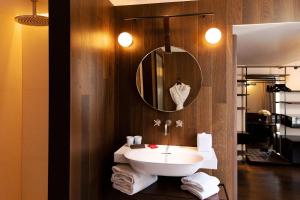 巴黎Hôtel Bourg Tibourg的浴室配有盥洗盆、镜子和毛巾