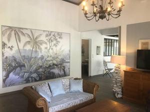 圣安娜La Sucrerie, magnifique villa avec Piscine的客厅配有沙发和墙上的绘画