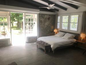 圣安娜La Sucrerie, magnifique villa avec Piscine的一间卧室配有一张床和吊扇