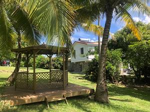 圣安娜La Sucrerie, magnifique villa avec Piscine的房屋旁的棕榈树,凉亭