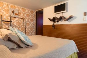 圣地亚哥Bella 269 Guest house的卧室配有一张床铺,墙上配有电视