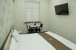 塔什干Premium Hotel 777的一间卧室配有一张床、一张桌子和一台电视