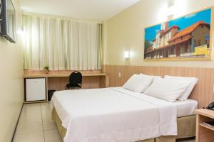 特雷西纳Hotel Express Arrey - Teresina的酒店客房带一张大床和一把椅子