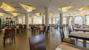 孔图尔西泰尔门卡帕索酒店的用餐室设有桌椅和窗户。