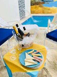 PantojaRG Sol 1的一张桌子,上面放着一盘奶酪和瓶装葡萄酒