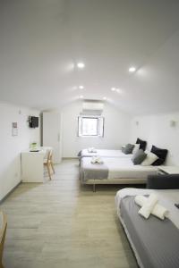 里斯本奥连特DNA公寓的白色的客房配有两张床和一张书桌