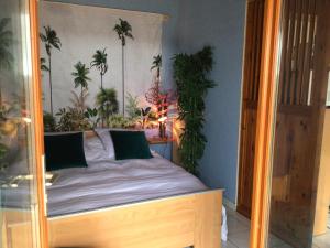雷克图尔Le gîte de Gascogne的卧室配有一张墙上棕榈树床。