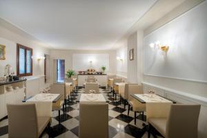 威尼斯Maison Venezia | UNA Esperienze的一间在房间内配有桌椅的餐厅