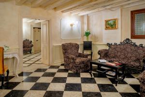 威尼斯Maison Venezia | UNA Esperienze的客厅配有两把椅子和一张桌子