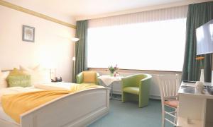 马兰迪Hotel Diekseequell Superior am Dieksee的一间卧室配有一张床、一张桌子和一个窗户。