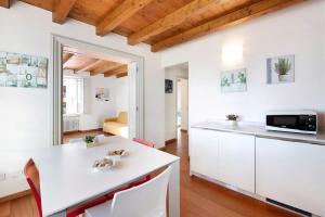 加尔尼亚诺Casa Grazia - Appartamento Luce的厨房配有白色橱柜和白色台面