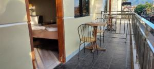 科隆Coron Vista Lodge的大楼内的阳台配有两把椅子和一张桌子
