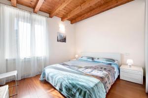加尔尼亚诺Casa Grazia - Appartamento Luce的白色的卧室设有床和窗户