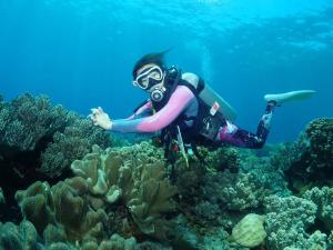 杜马格特Oceanism海洋主义潜水度假酒店的珊瑚礁上戴着浮潜面具的人