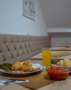 索科矿泉村Apartments Ozren的餐桌,盘子和一杯橙汁