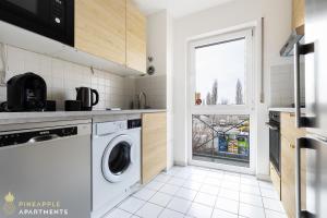德累斯顿Pineapple Apartments Dresden Mitte III - free parking的厨房配有洗衣机和窗户。