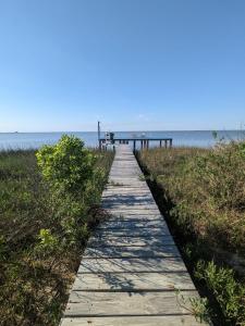 Bolivar PeninsulaGlamping on the Bay with fishing dock的通往海滩码头的木板路