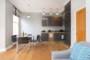伦敦Comfy 1 bed flat in Tufnell Park的厨房以及带桌椅的起居室。