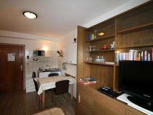 施泰纳赫布伦纳特林瑟斯特5号公寓的小厨房配有小桌子和电视