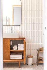 卡西斯Suites 23的浴室设有水槽和带毛巾的架子。