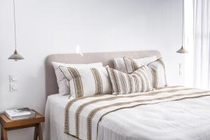 卡西斯Suites 23的白色卧室配有带条纹枕头的床