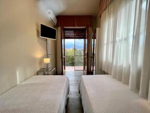 马尔米堡Villa Allende的带美景窗户的客房内的两张床
