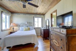 海洋岛海滩Ocean Isle Beach Home with Canal Views!的一间卧室配有一张床和一个带电视的梳妆台