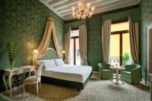 威尼斯Maison Venezia | UNA Esperienze的绿色卧室配有一张床和吊灯