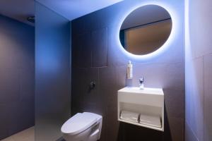 伦敦Zedwell Underground Hotel Tottenham Court Rd的浴室设有白色的卫生间和镜子