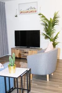 米尔顿凯恩斯Luxurious MK Apartment-Campbell Park的客厅配有电视、椅子和桌子