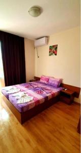 普里莫尔斯科Guest House Natali的一间卧室配有一张带紫色床单的大床