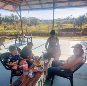 莱蒂西亚Glamping Amazonas的一群人坐在野餐桌旁