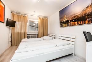 科隆Easy Apartments Work and Stay Cologne的白色客房的两张床,配有电视