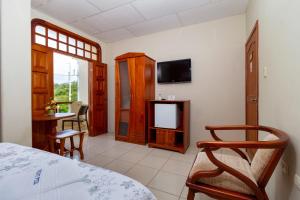 阿约拉港拉古纳别墅酒店酒店的一间卧室配有一张床、一台电视和一张桌子