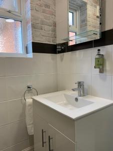 斯卡伯勒The Headlands Hotel的白色的浴室设有水槽和镜子