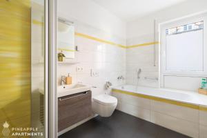 德累斯顿Pineapple Apartments Dresden Zwinger II - 70 qm - 1x free parking的白色的浴室设有水槽、卫生间和窗户。