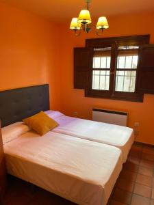 昆卡Apartamentos Hoz del Huécar的一间带两张床的卧室,拥有橙色的墙壁