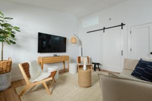 费尔菲尔德DUNE Fairfield Beach的客厅配有沙发、椅子和电视