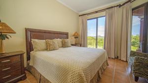 巴希利托Bougainvillea 1101 Luxury Apartment - Reserva Conchal的一间卧室设有一张床和一个大窗户