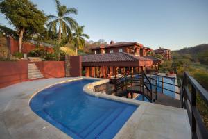 巴希利托Bougainvillea 1101 Luxury Apartment - Reserva Conchal的房屋前有游泳池的房子