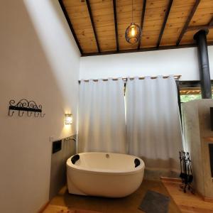 萨普卡伊米林Chalés Quatro Estações的带窗户的浴室设有大浴缸