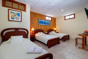 阿约拉港拉古纳别墅酒店酒店的酒店客房设有两张床和一张桌子。